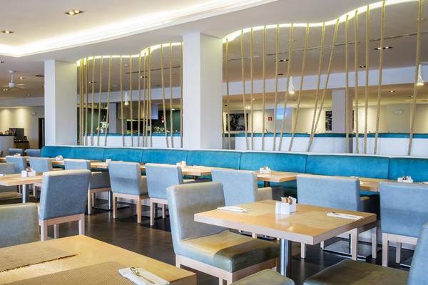 Innenansicht des Restaurants im Melia Dunas Beach Resort & Spa mit blauen Sofas und Tischen.