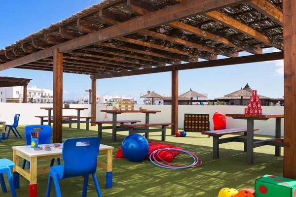 Kinderbereich auf der Dachterrasse des Melia Dunas Beach Resort & Spa mit Tischen, Stühlen und Spielzeug.