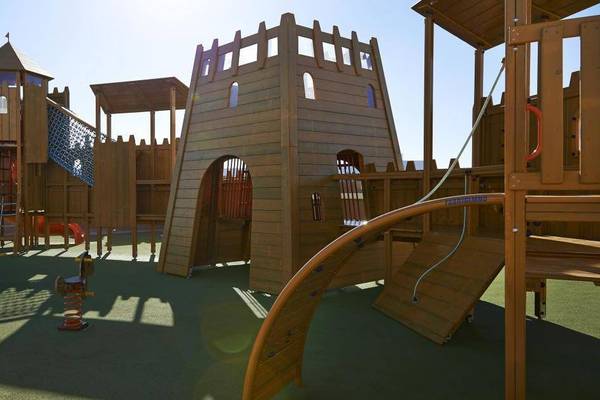 Kinderspielplatz im Melia Dunas Beach Resort & Spa mit Holzstrukturen und Rutschen.