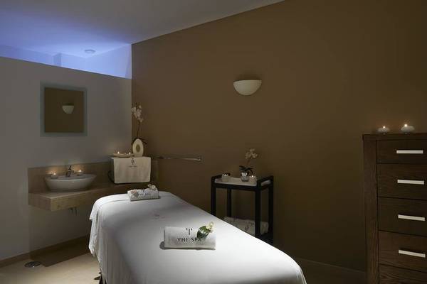 Behandlungsraum im Melia Dunas Beach Resort & Spa mit Massageliege, Waschbecken und Dekor.