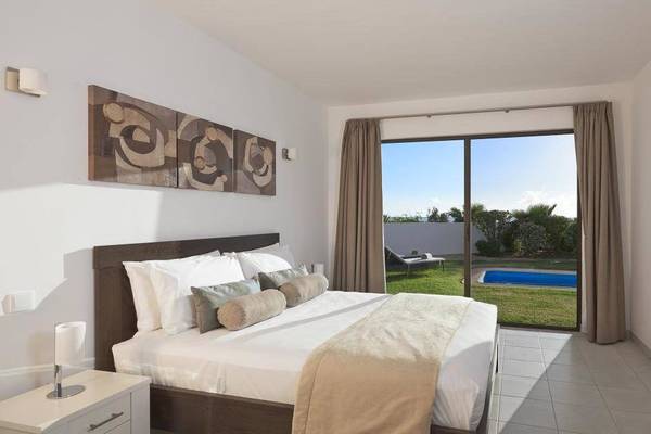 Schlafzimmer im Melia Dunas Beach Resort & Spa mit einem großen Bett, Panoramafenstern und einem Swimmingpool.