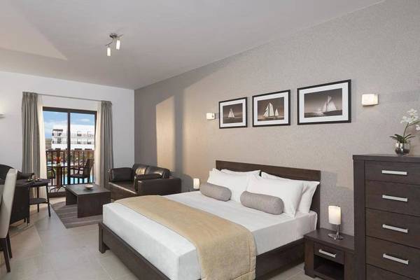 Hotelzimmer im Melia Dunas Beach Resort & Spa mit Bett, Schreibtisch und Balkon.
