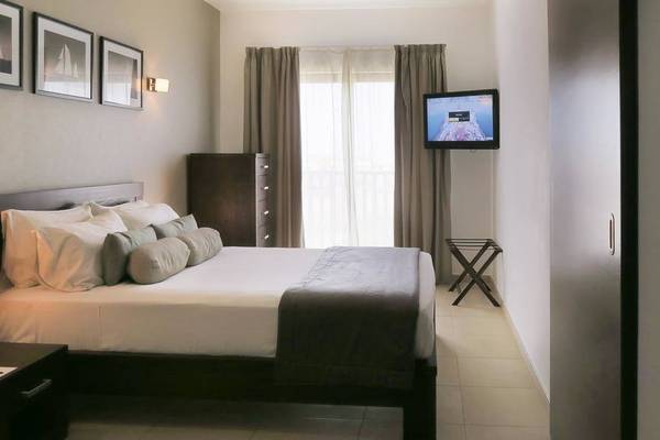 Hotelzimmer im Melia Dunas Beach Resort & Spa mit Doppelbett, Fernseher, Nachttischen und Couch.
