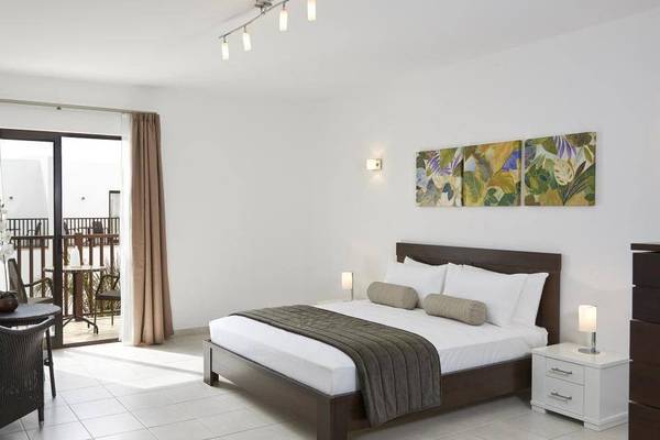 Schlafzimmer im Melia Dunas Beach Resort & Spa mit einem großen Bett, einem Balkon und einem Balkontisch.
