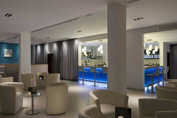 Loungebereich des Melia Dunas Beach Resort & Spa mit weißen Sesseln und einer Bar.