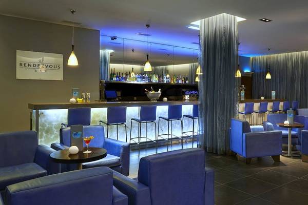 Bar und Loungebereich des Melia Dunas Beach Resort & Spa mit blauen Stühlen und Theke
