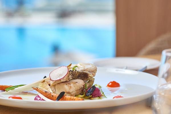 Gerichteter Teller im Mayia Exclusive Resort & Spa mit Blick auf den Pool.