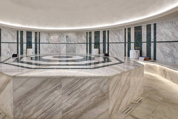 Innenansicht des Hamams im Mayia Exclusive Resort & Spa mit marmornen Wänden und einem zentralen achteckigen Tisch.