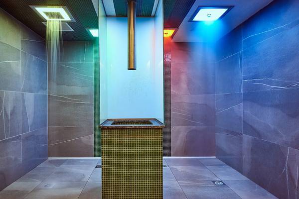 Dusche im Mayia Exclusive Resort & Spa mit farbigen Lichtern und Marmorfliesen.