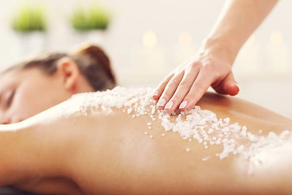 Eine Frau im Mayia Exclusive Resort & Spa erhält eine Salzmassage auf ihrem Rücken.