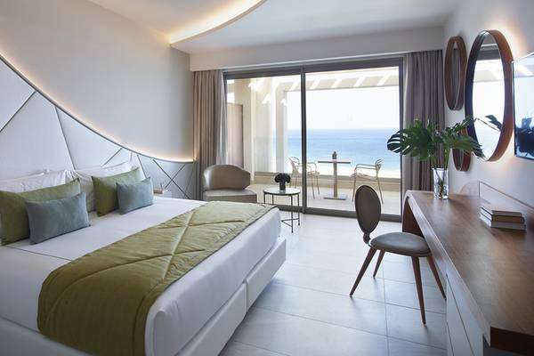 Mayia Exclusive Resort & Spa Zimmer mit Meerblick, inklusive Bett, Kissen, Schreibtisch, Stühle, und Terrasse mit Meersicht.