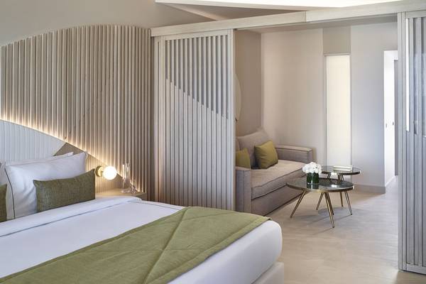 Schlafzimmer im Mayia Exclusive Resort & Spa mit Bett, Couch, Tisch und Dekor