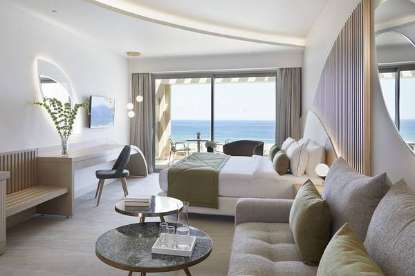 Innenansicht eines Zimmers im Mayia Exclusive Resort & Spa mit Meerblick, Bett, Sofa und Schreibtisch