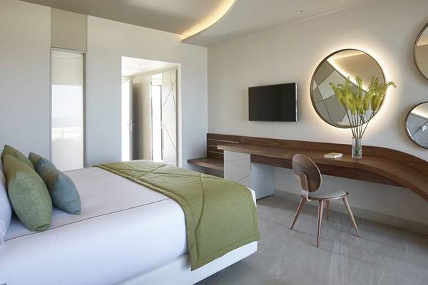 Schlafzimmer im Mayia Exclusive Resort & Spa mit Bett, Schreibtisch und Deko