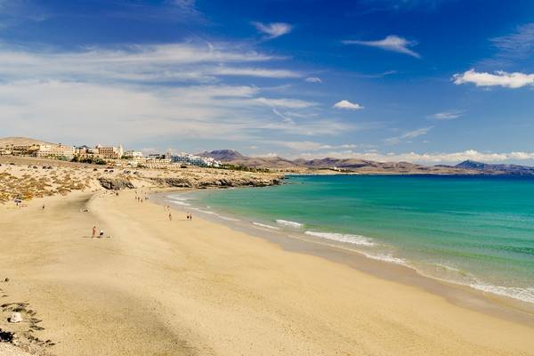 H10 Playa Esmeralda Hotel Strand mit vielen Besuchern und blauem Himmel