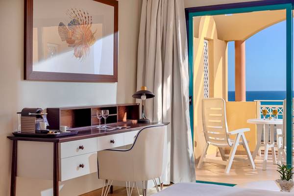 Zimmer im H10 Playa Esmeralda Hotel mit Schreibtisch und Meerblick.