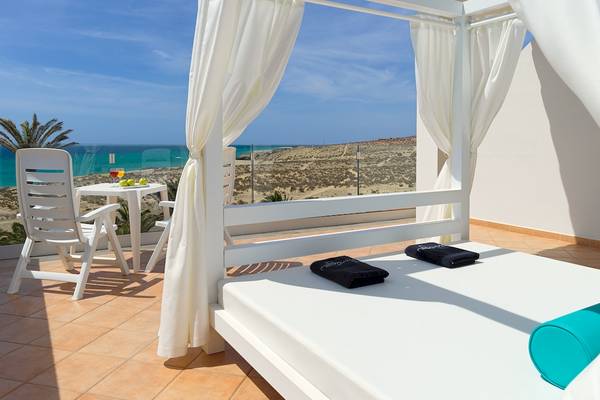 Balkonbett im H10 Playa Esmeralda Hotel mit Meerblick, Tisch und Stühlen.