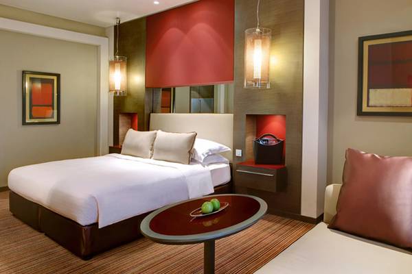 Ein modernes Hotelzimmer im Park Rotana Abu Dhabi mit einem Bett, Tisch und Dekor.