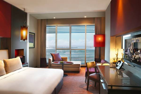 Innenansicht eines Hotelzimmers im Park Rotana Abu Dhabi mit großem Fenster und Meerblick.