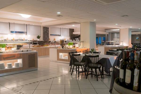 Frühstücksraum im Elea Beach Hotel mit Tischen, Stühlen und Buffet.