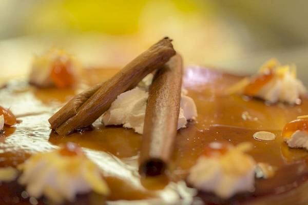 Nahaufnahme eines Desserts mit Zimtstangen und Sahne, serviert im Elea Beach Hotel.