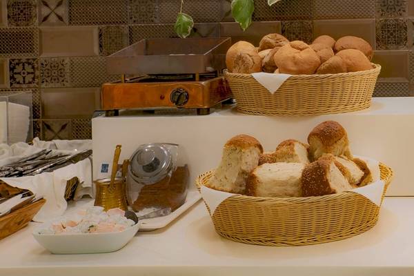 Frühstücksbuffet im Elea Beach Hotel mit Brotkörben, Toaster und Gebäck.