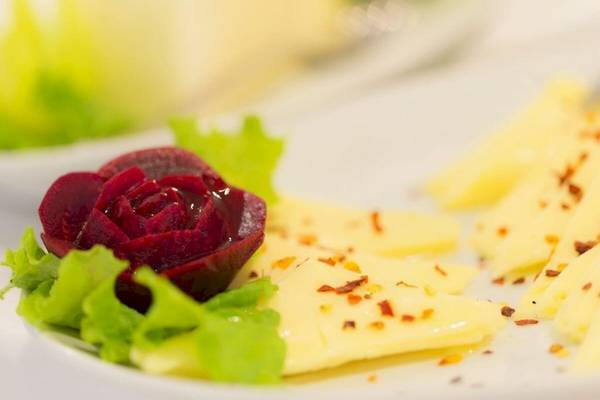 Nahaufnahme eines Gerichts mit roter Rübe und Käse auf einem weißen Teller.