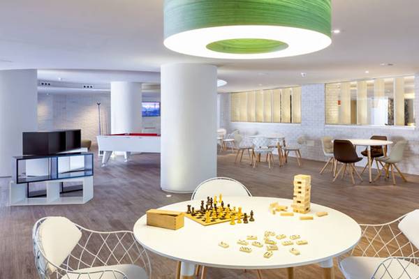 Spielzimmer des Tigotan Lovers & Friends Hotel mit Tischspielen, Sofas und weißer Inneneinrichtung.