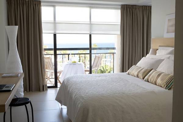 Schlafzimmer des Sentido Sandy Beach Hotel mit Blick auf den Balkon und das Meer.