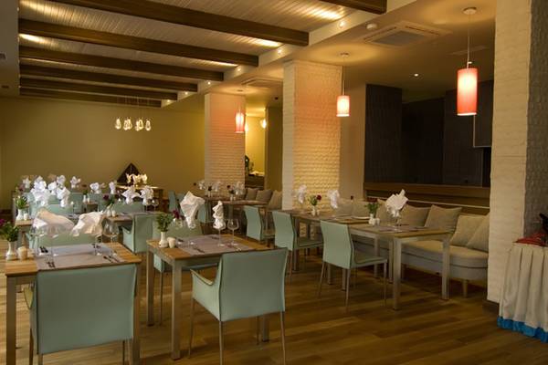 Innenbereich des Restaurants im Casa De Maris Spa & Resort mit gedeckten Tischen und Stühlen.