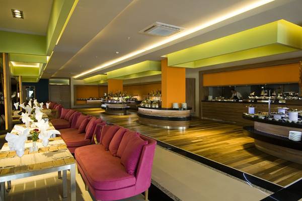 Innenansicht des Restaurants im Casa De Maris Spa & Resort mit Holzboden und pinken Sofas.