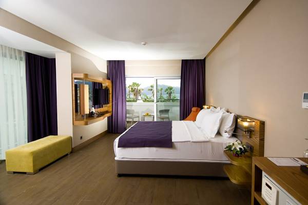 Innenansicht eines Hotelzimmers im Casa De Maris Spa & Resort mit Doppelbett, Balkon und Meerblick.