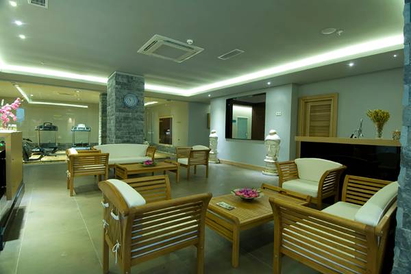 Loungebereich im Casa De Maris Spa & Resort mit Holzmöbeln und einer Steinmauer.