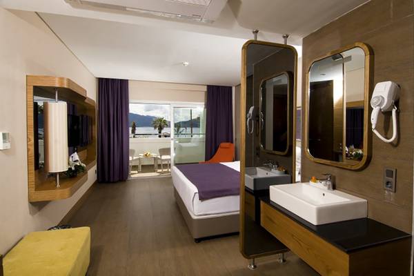 Innenansicht eines Hotelzimmers im Casa De Maris Spa & Resort mit Bett, Fenster und Badezimmer.