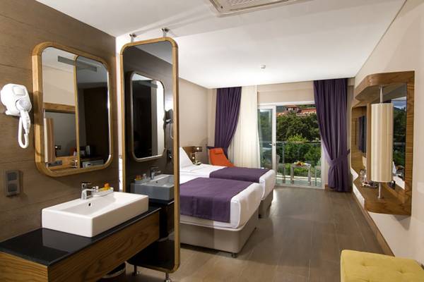 Innenansicht eines Hotelzimmers im Casa De Maris Spa & Resort mit zwei Betten, einem Waschbecken und einem Haartrockner.