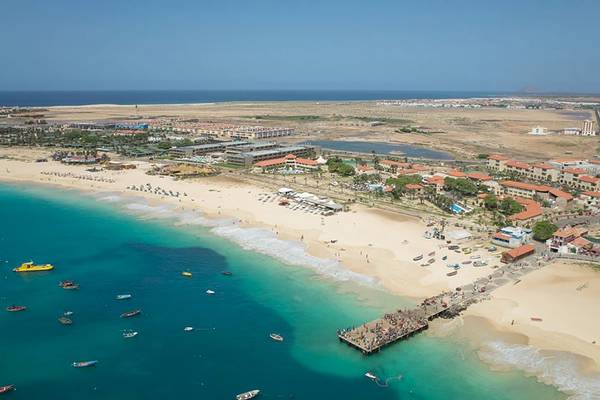Luftaufnahme des Sobrado Hotels mit Strand, Gebäuden und vielen Booten im Wasser.