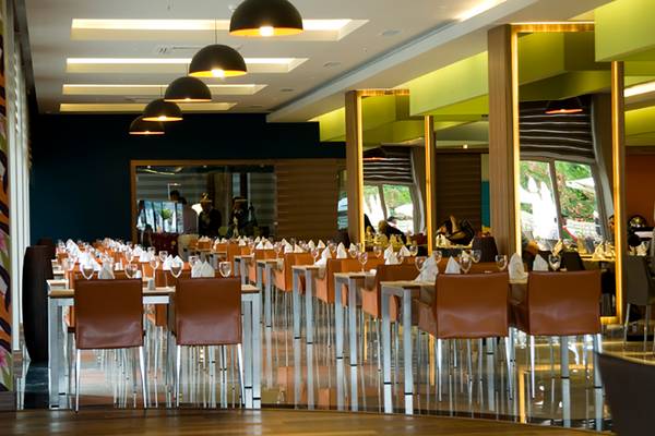 Innenansicht des Restaurants im Casa De Maris Spa & Resort mit gedeckten Tischen und hängenden Lampen.