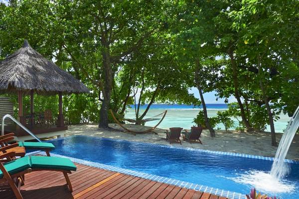 Außenpool des Hilton Seychelles Labriz Resort & Spa mit Lounge-Stühlen und einem Blick auf den Ozean.