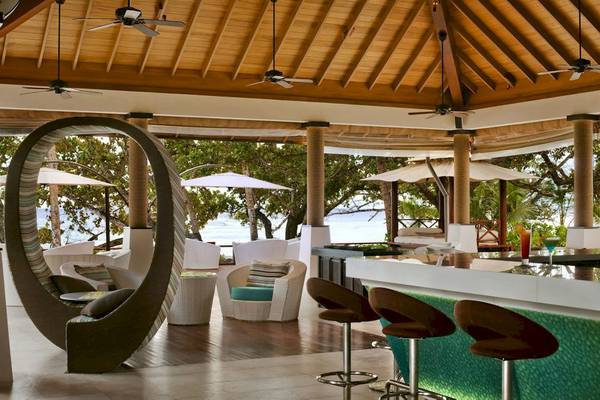 Innenbereich der Lounge im Hilton Seychelles Labriz Resort & Spa mit Sitzmöbeln und Blick aufs Meer.