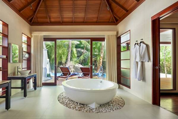 Ein Badezimmer im Hilton Seychelles Labriz Resort & Spa mit einer großen Badewanne und zwei Waschbecken.