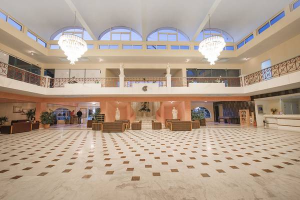 Lobby des Eurovillage Achilleas Hotels mit Marmorboden, Sofas und Kronleuchtern.