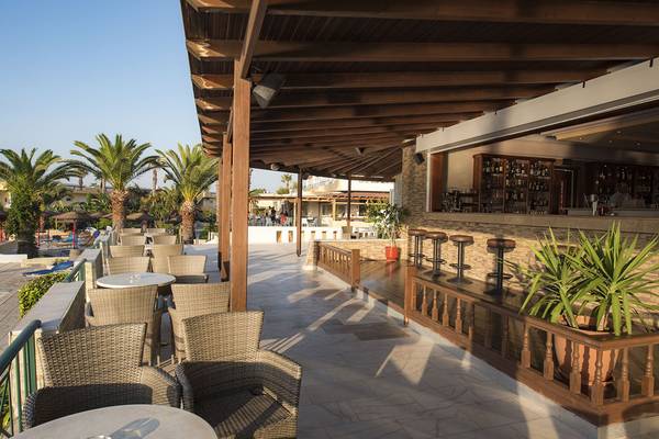 Außenbar der Eurovillage Achilleas Hotel Terrasse mit Tischen und Stühlen unter Holzdach.