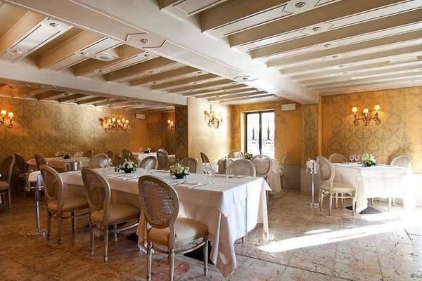 Speisesaal des CHC Continental Hotels mit eleganten Tischdekorationen und Kronleuchtern.