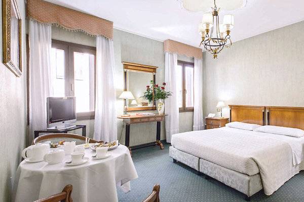 Hotelzimmer im CHC Continental mit Bett, Tisch, Fernseher und Dekor.