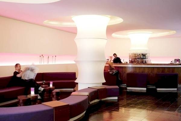 Lobbybereich des Ku Damm 101 Hotels mit Sitzbereichen und Bar.