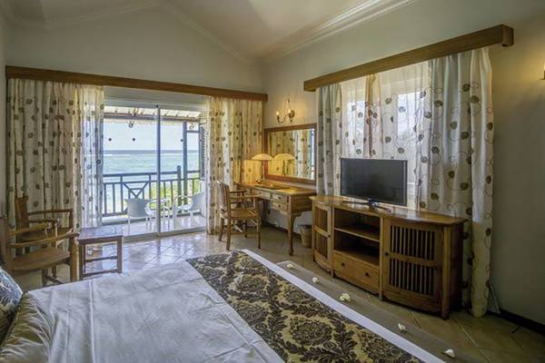 Schlafzimmer im Le Peninsula Bay Beach Resort & Spa mit Meerblick, Bett, Fernseher und Schreibtisch.