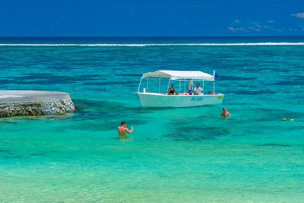 Le Peninsula Bay Beach Resort & Spa Boot im Meer mit Schwimmern und Sonnenschirm