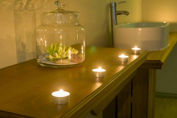 Badezimmer im Le Peninsula Bay Beach Resort & Spa mit Kerzen und Glasvase