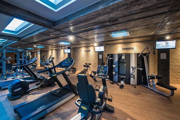 Innenansicht des Fitnessstudios des Corissia Princess Hotels mit verschiedenen Geräten und Monitoren.