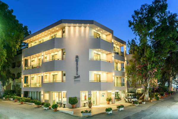 Außenansicht des Corissia Princess Hotels bei Nacht mit beleuchteten Fenstern und gut gepflegten Gärten.